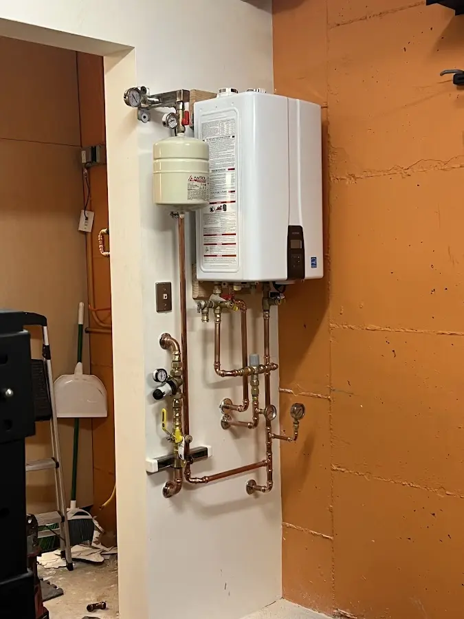 Plumbing technician inspecting water heater connections in Colorado Springs